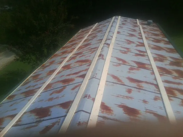 Rusted metal roof panels with new wood purlins before replacement — Storm Damage Roof Repair in Randallstown by Roofing Brothers