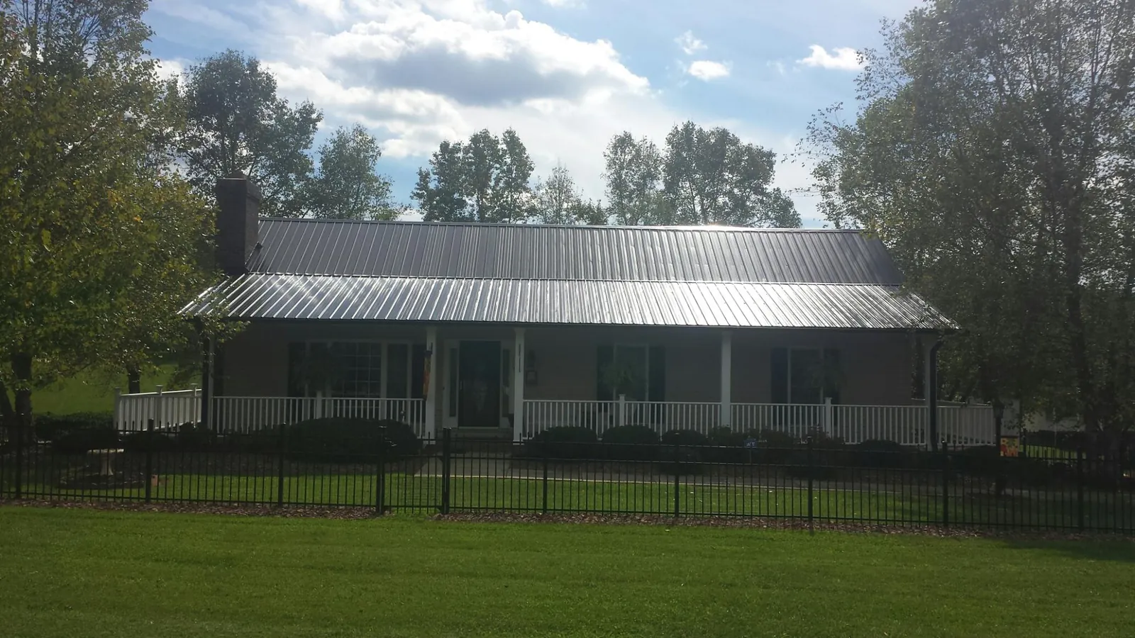 Gray metal roof on a brick ranch with a full width front porch — Gutter Guard Installation work by our crew in Randallstown