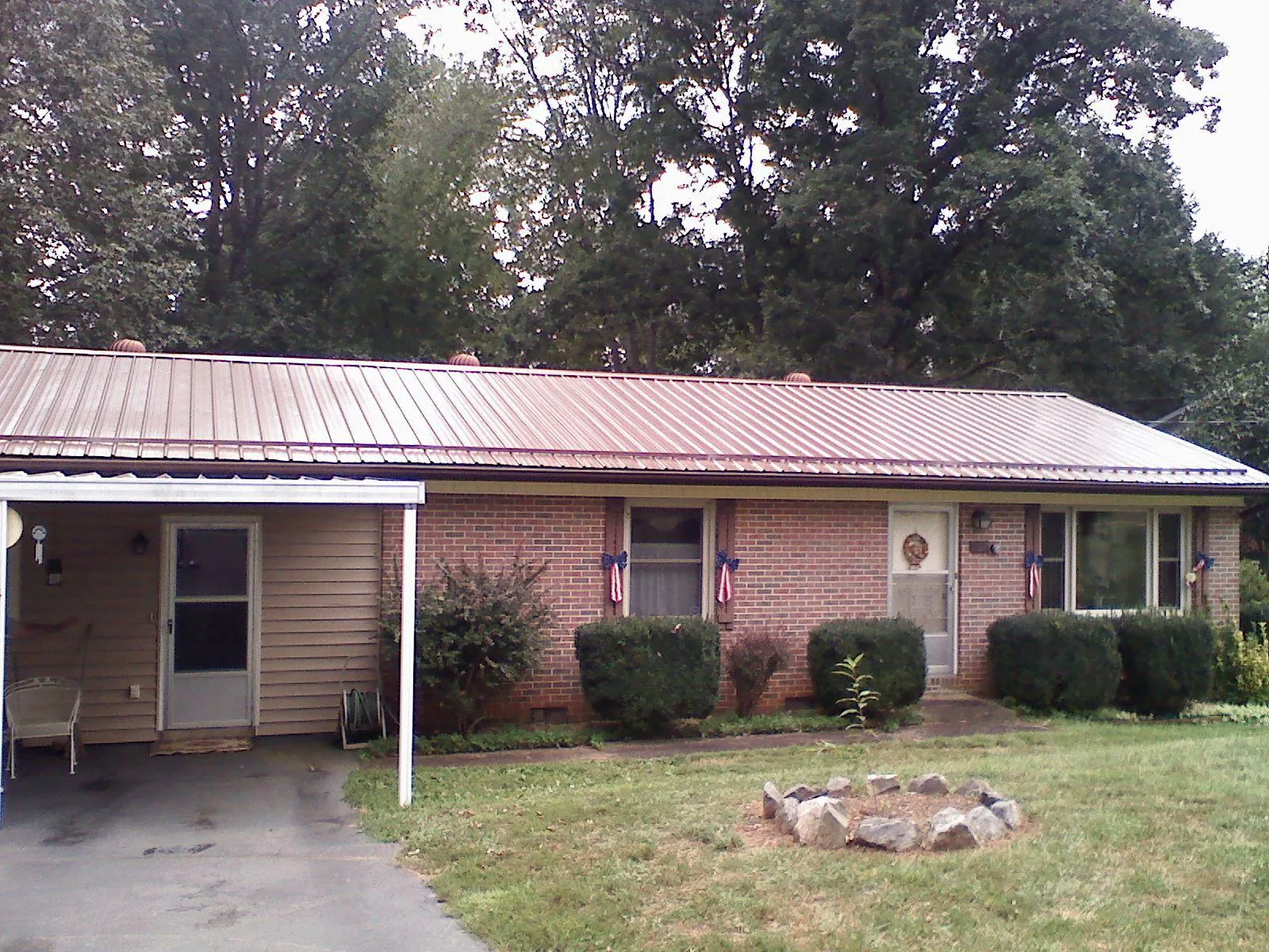 Bronze metal roof and carport on a brick ranch home — Roof Repair work by our crew in Randallstown