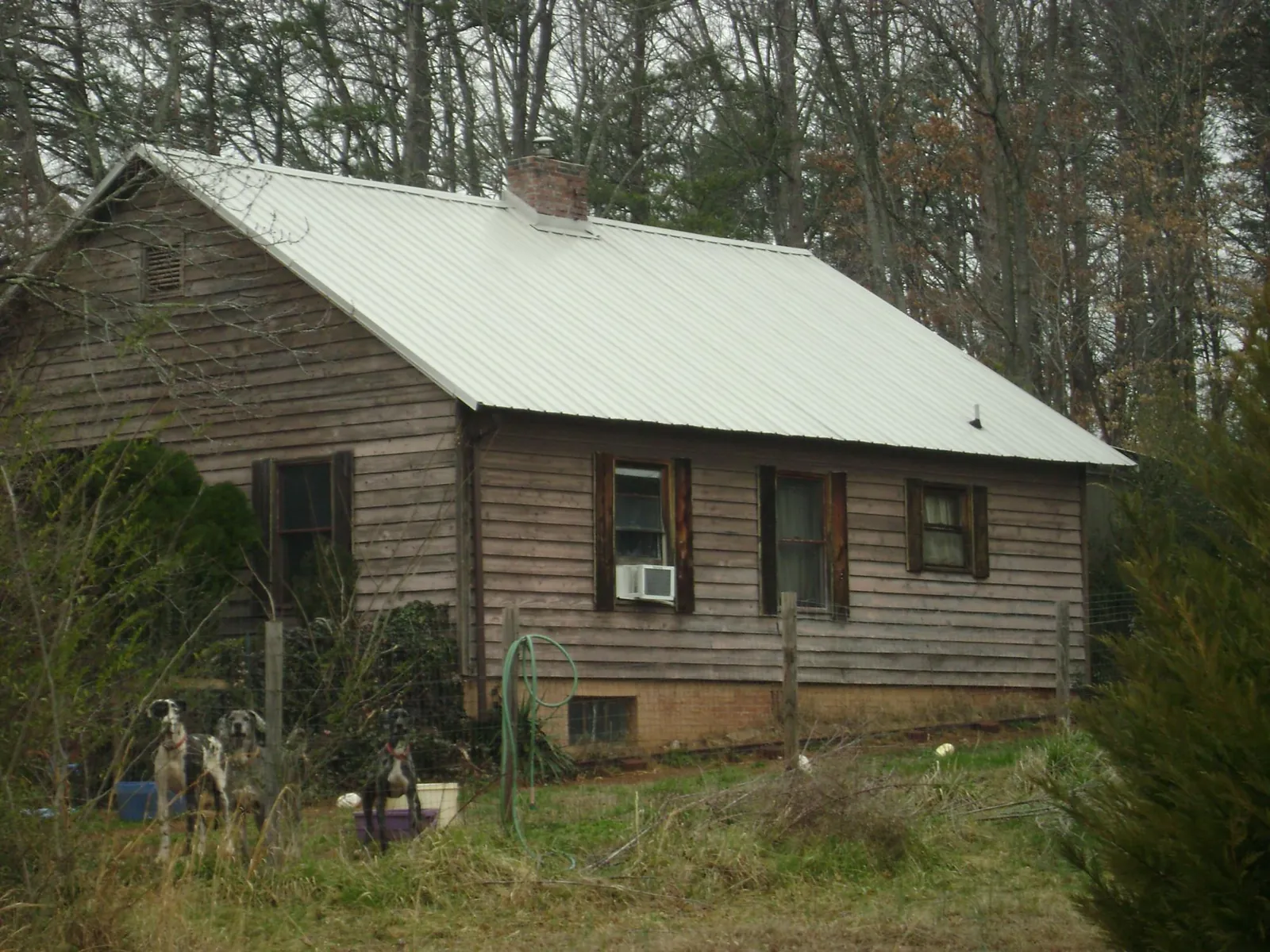White metal roof on an old wood sided farmhouse, from a Metal Roof Installation job in Randallstown